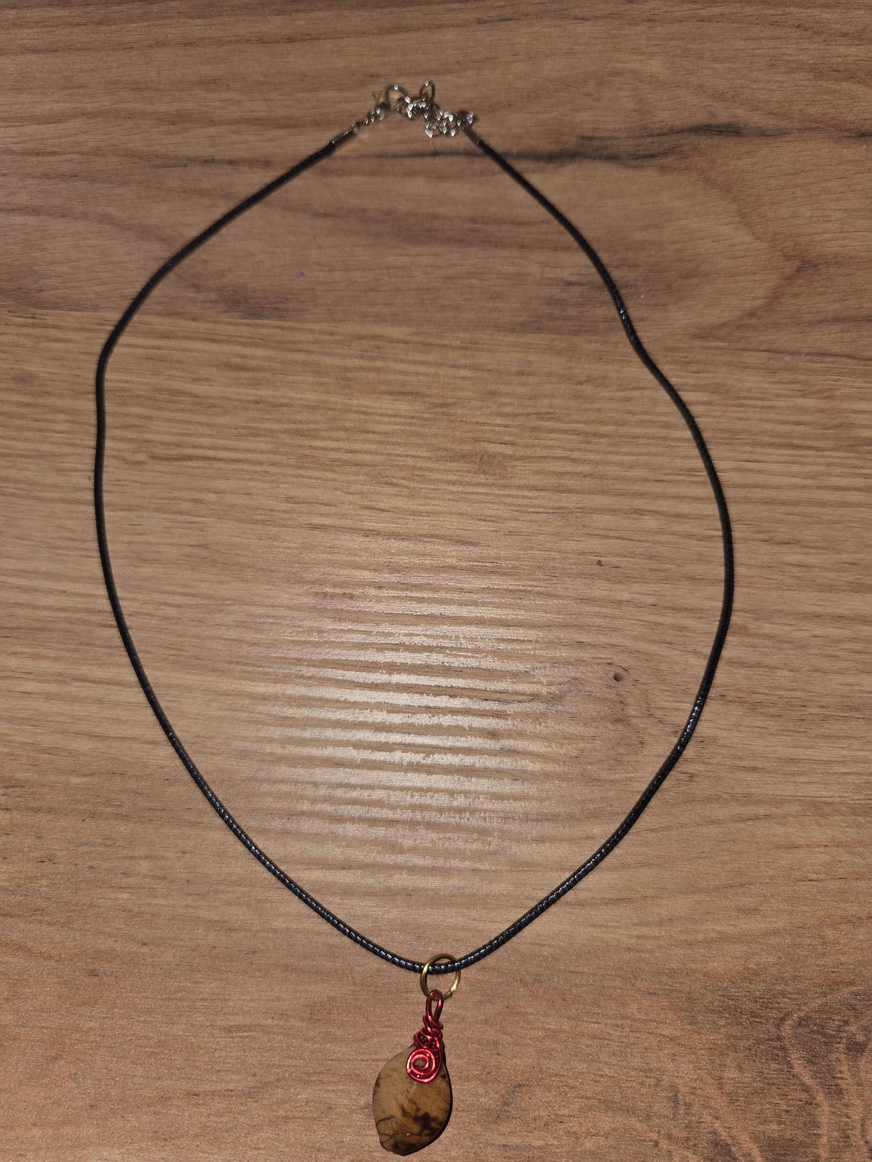 Collier grosse perle naturelle avec fil métallique rouge sur cordon noir